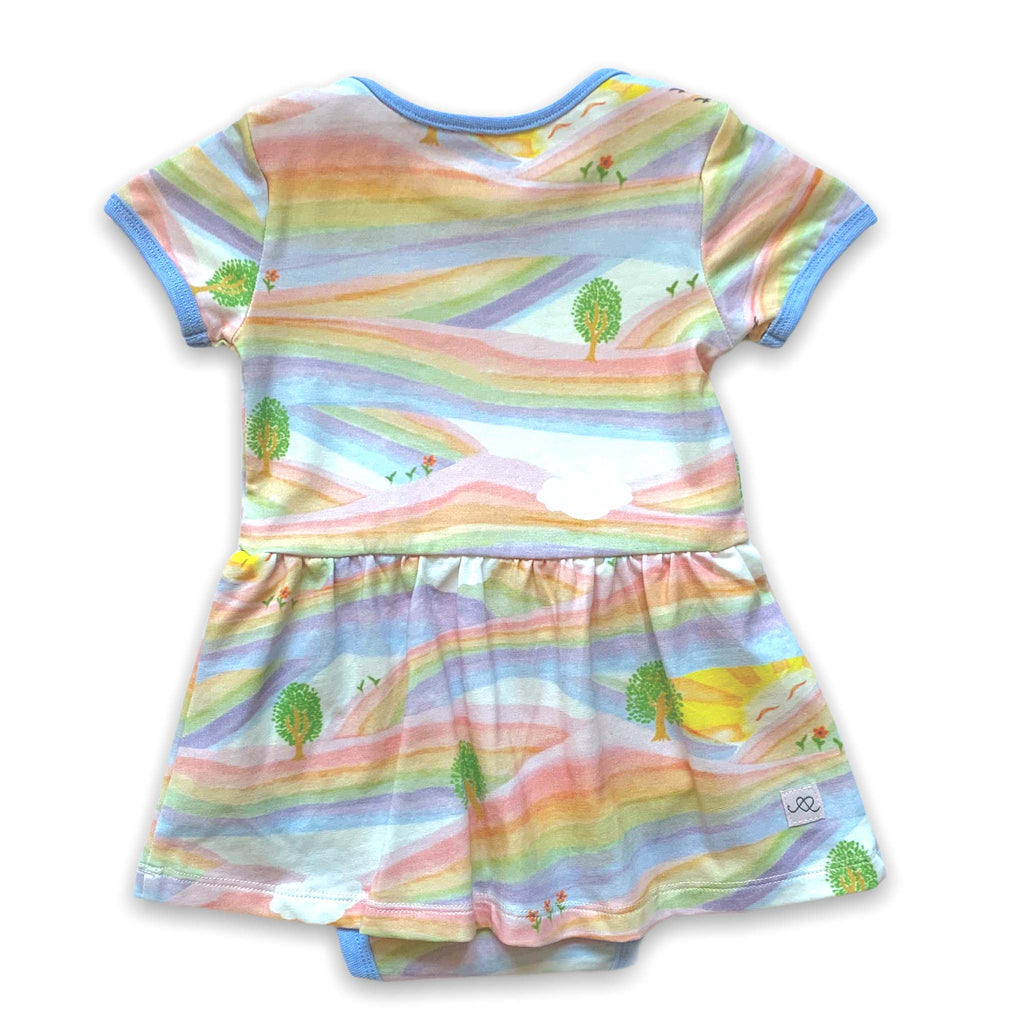Anise & Ava baby onesie dress front in genderless Sunray Rainbow print back with contrast ribbing and envelop neck for easy wearing. 