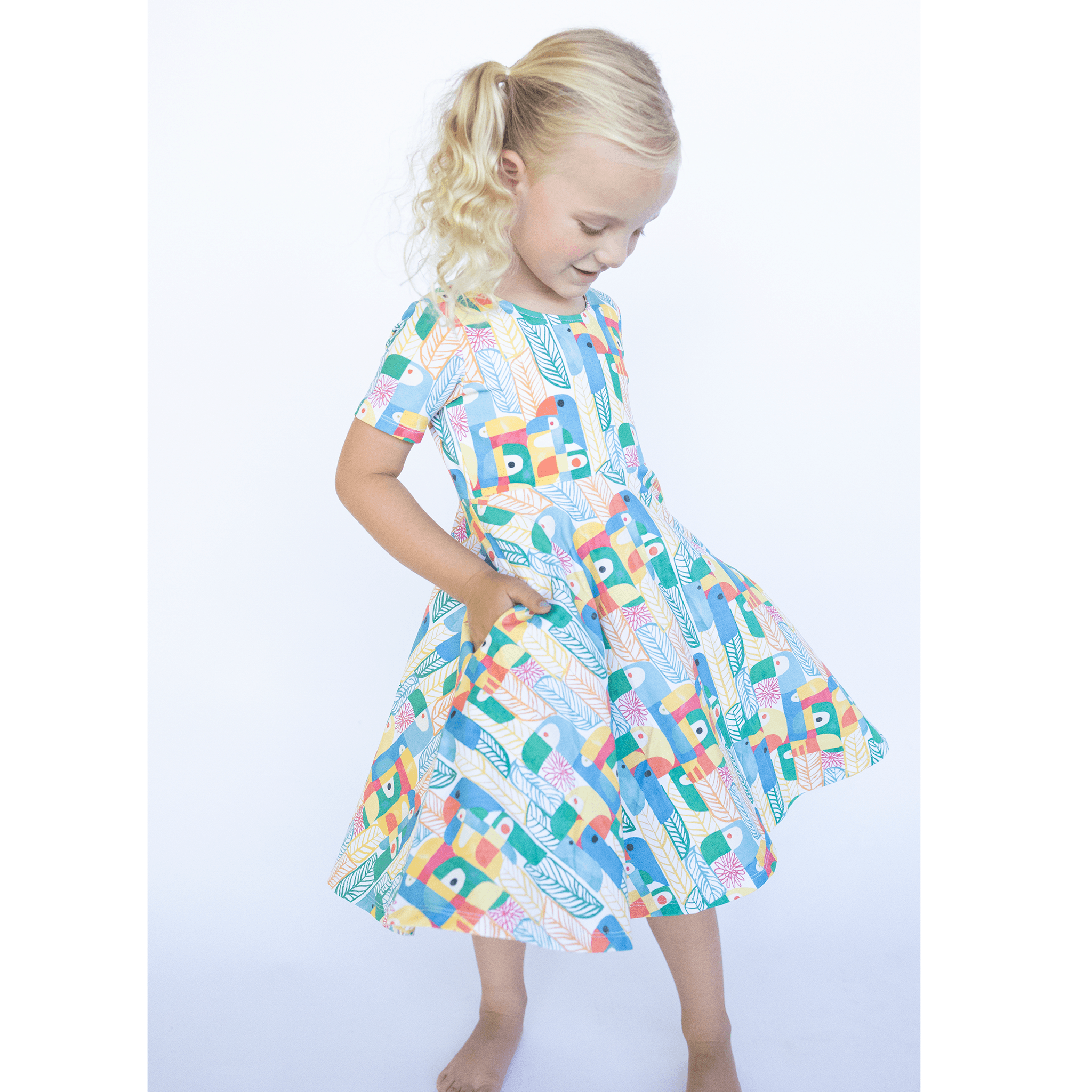 Anise & Ava exclusive hand drawn Parrots print eco friendly printed on luxury stretch cotton. Designed and made to match siblings styles. Short sleeves Journey dress is Anise & Ava best selling style, made with deep pockets to hold all the treasures. Siblings matching styles Cory button down shirt and baby Wren snap body onesie. 