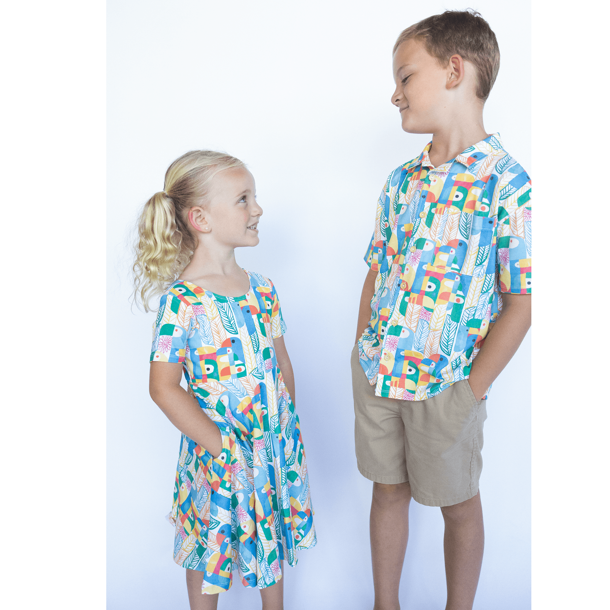 Anise & Ava exclusive hand drawn Parrots print eco friendly printed on luxury stretch cotton. Designed and made to match siblings styles. Short sleeves Journey dress is Anise & Ava best selling style, made with deep pockets to hold all the treasures. Siblings matching styles Cory button down shirt and baby Wren snap body onesie. 