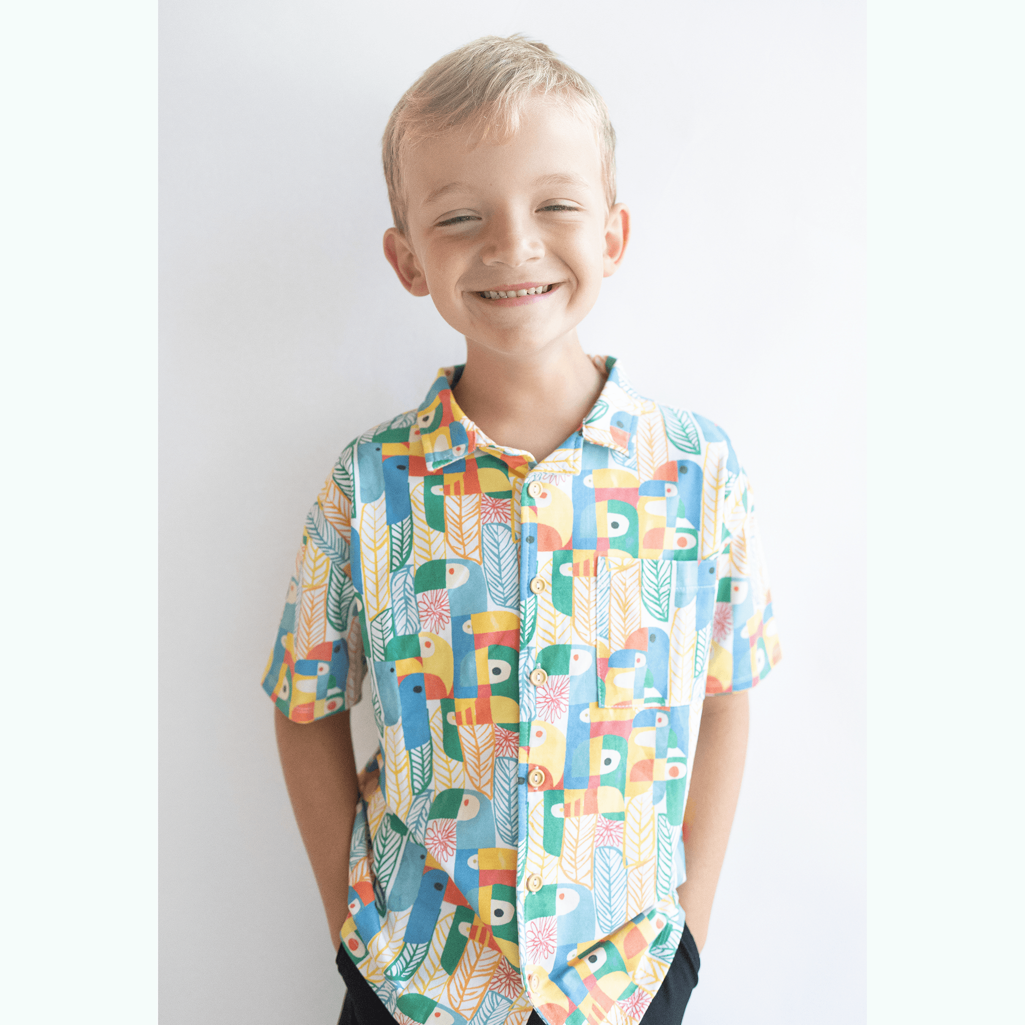 Anise & Ava exclusive hand drawn genderless Parrots print, eco friendly printed on luxury stretch cotton into our new button down collar vacation shirt. Designed and made to match siblings styles in Journey girls dresses & our best selling baby Wren body onesie. Dress your family in this happy exclusive print made for all boys & girls. 