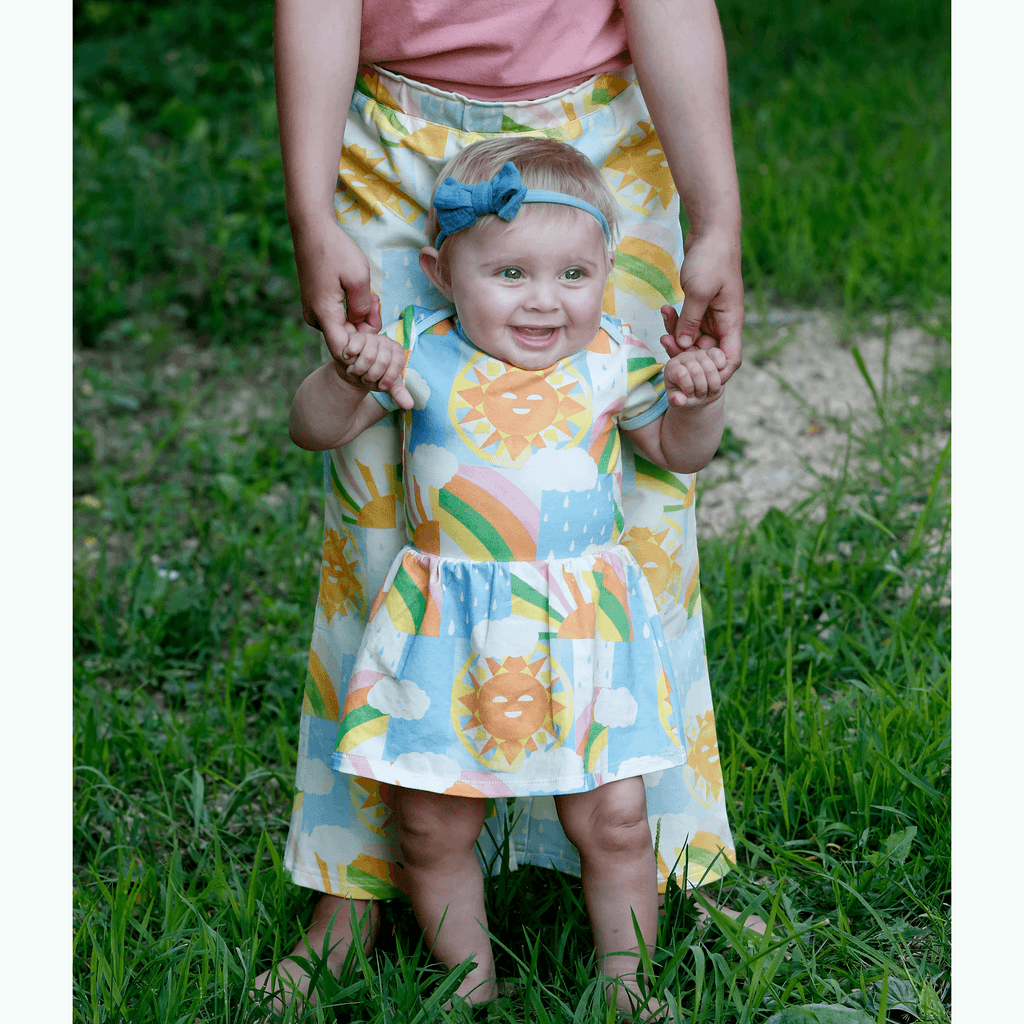 Anise & Ava exclusive hand drawn art eco friendly printed on the softest stretch cotton to match with other siblings' styles. Baby dress with enveloped neck and snaps for easy changing.