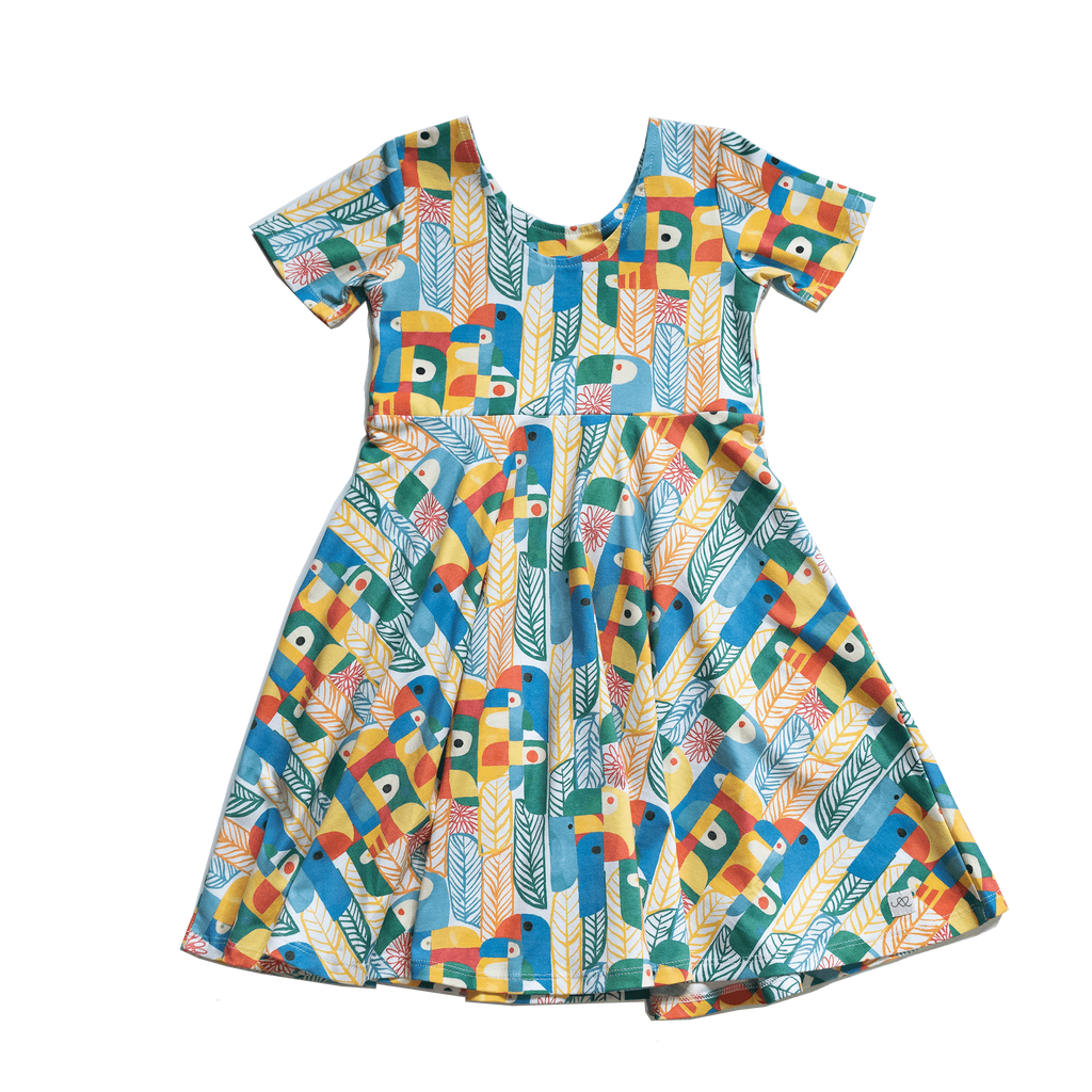 Anise & Ava exclusive hand drawn Parrots print eco friendly printed on luxury stretch cotton. Designed and made to match siblings styles. Short sleeves Journey dress is Anise & Ava best selling style, made with deep pockets to hold all the treasures. Siblings matching styles Cory button down shirt and baby Wren snap body onesie. 