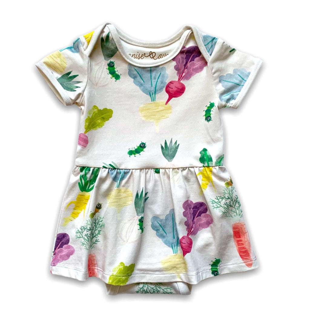 Anise & Ava baby onesie dress front in genderless Happy Roots vegetables print front with ribbing and envelop neck for easy wearing. 