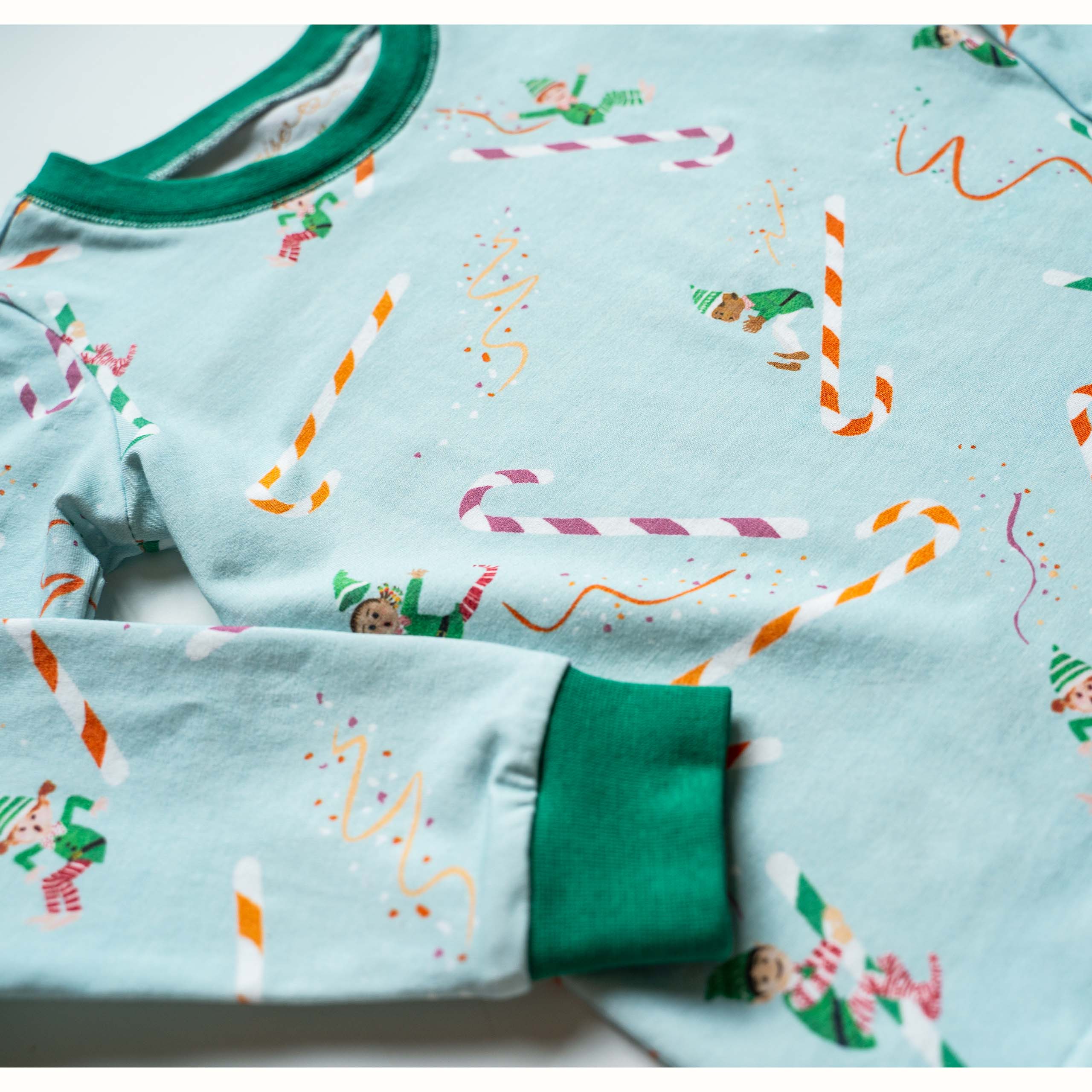 Anise & Ava 2 pcs holiday pajamas made to twin with baby's zip onsie. Created and drawn in house with an exclusive original genderless artwork you won't find anywhere else. Jam up with all the elvies of different skin color and ethnicities sliding down  candy cane slides!!!