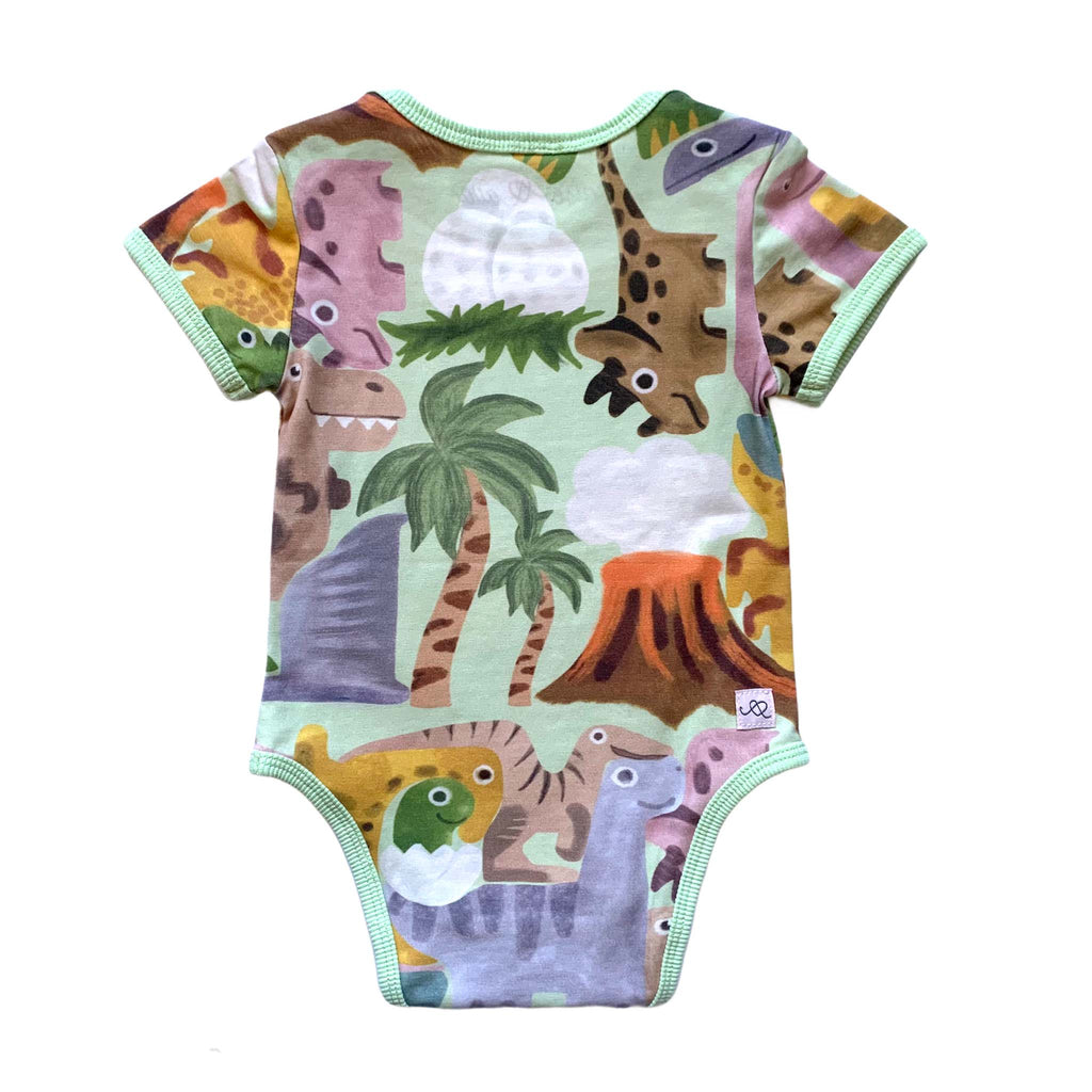 Anise & Ava genderless baby onesie body back in Dino Puzzle print with ribbing and envelop neck for easy wearing. 